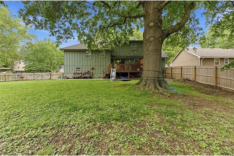 Peaceful backyard retreat shaded by mature trees, offering privacy, comfort, and room to unwind after exploring Kansas City or attending World Cup events.