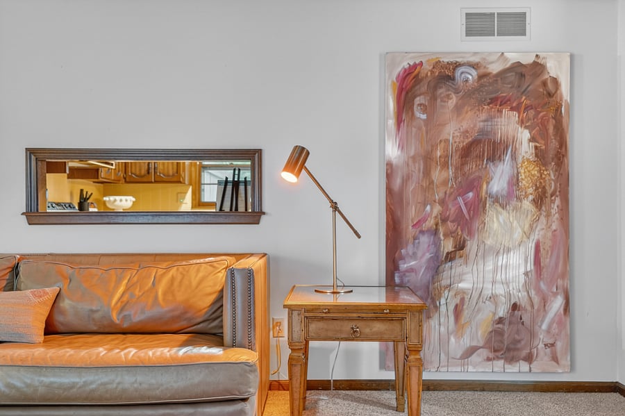 Stylish reading corner with modern lighting, cozy seating, and elegant artwork for a relaxing atmosphere.