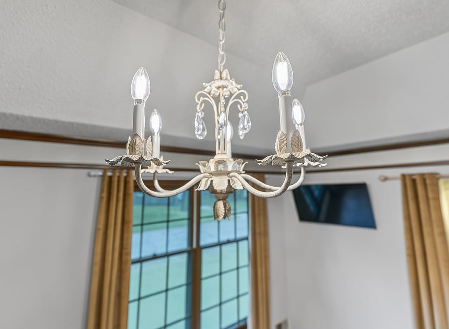 Elegant chandelier detail adding charm, warmth, and sophistication to the beautifully styled bedroom.
