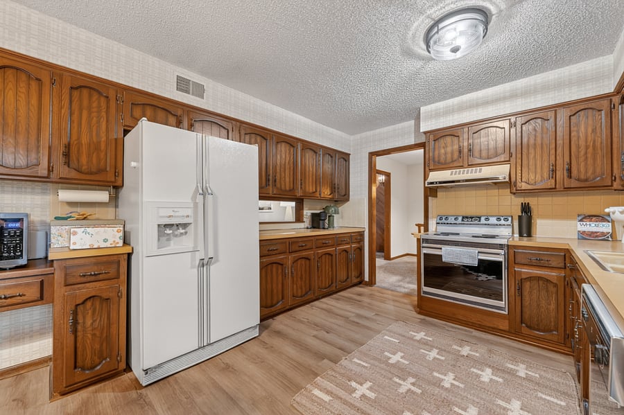 Bright and airy kitchen layout with classic cabinetry, open walkways, and plenty of natural light.