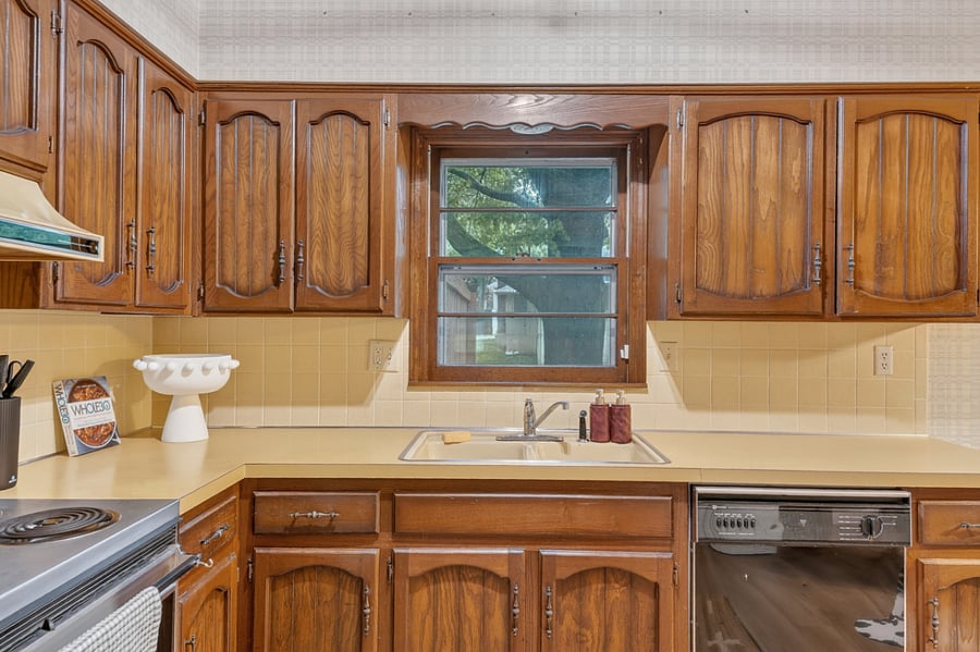 Bright kitchen workspace featuring rich wood finishes, natural light, and plenty of counter space.