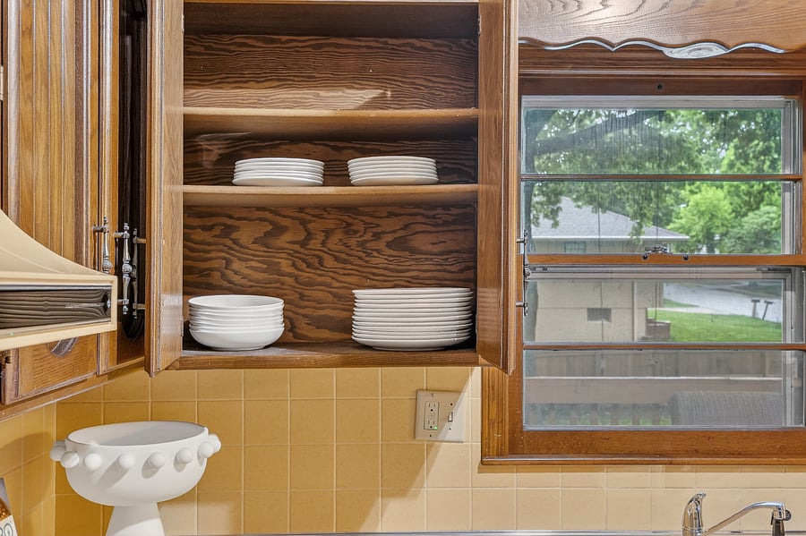 Open shelving detail with neatly styled dishes and natural textures creating a cozy, homey feel.