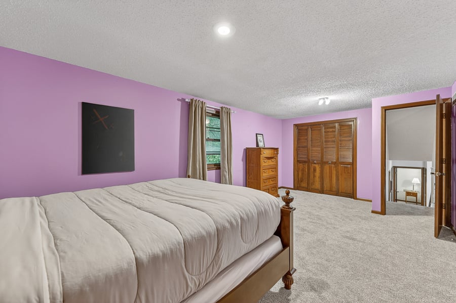 Bright and inviting bedroom featuring cozy bedding, natural light, and a clean modern feel.