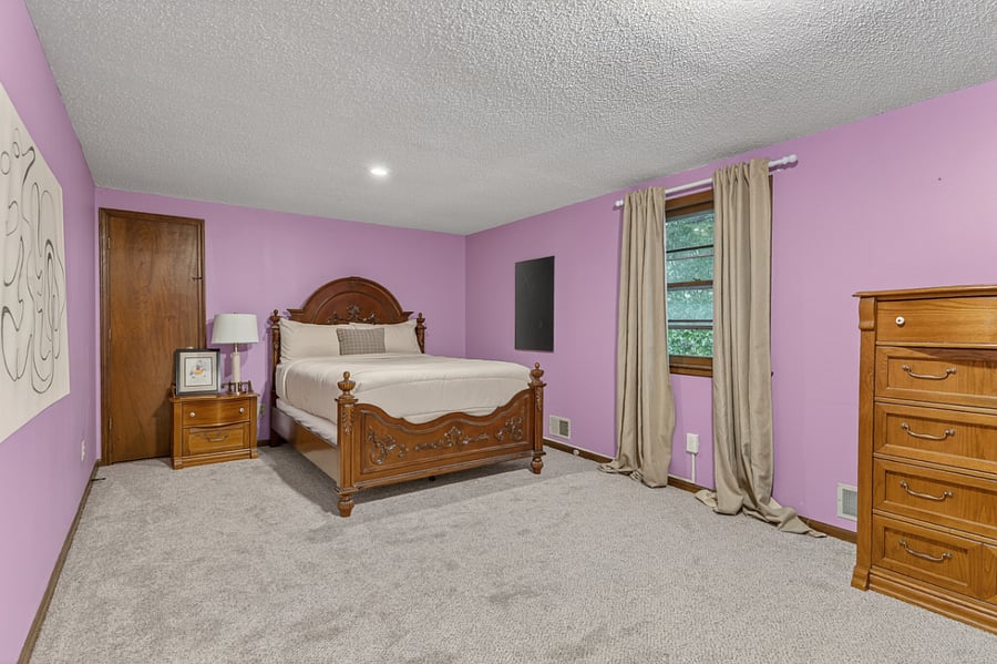 Spacious bedroom retreat with soft tones, plush carpeting, and plenty of room to relax in comfort.