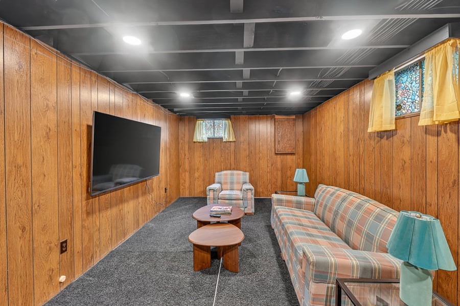 Spacious basement lounge with cozy seating, large TV, and a relaxing atmosphere perfect for movie nights.