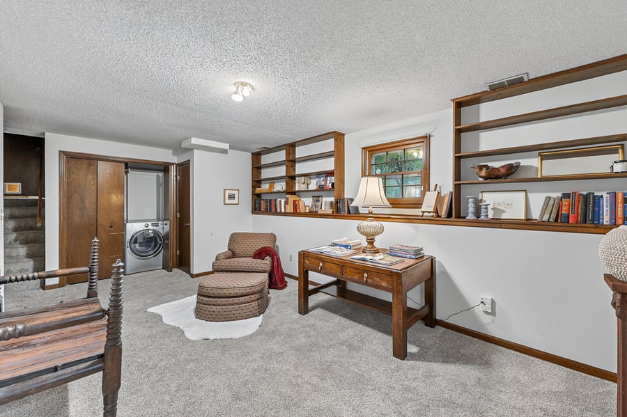 Open concept workspace with cozy seating, built in shelving, and plenty of flexible functionality.