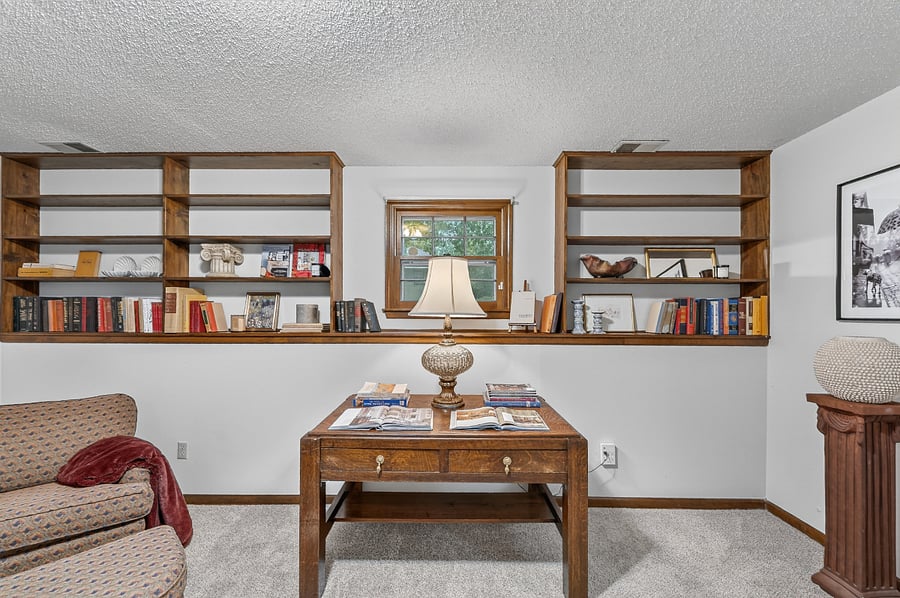 Inviting office setup featuring custom bookshelves and a comfortable workspace filled with natural light.