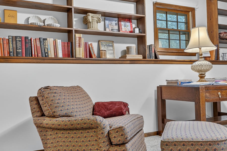 Cozy corner seating beneath built in shelving, perfect for relaxing with a book or morning coffee.