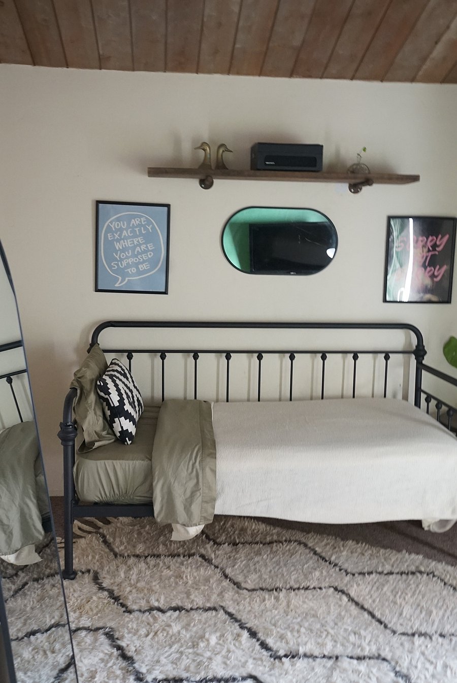 Bedroom 2 features a Twin Size Farmhouse style Bedframe with a tempurpedic mattress, stylish floor mirror, custom artframes, and a stylish wool rug to frame the space.  