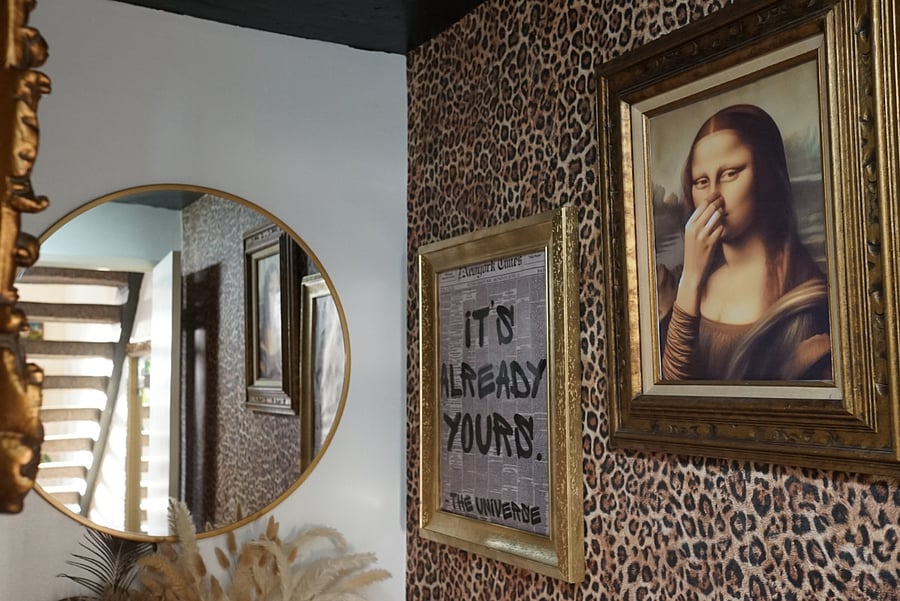 Downstairs (main level) Half Bathroom. Featuring custom leopard print wallpaper, black vertical tiling, & custom curated art to create a distinct visionary experience for guests + tenants. 
