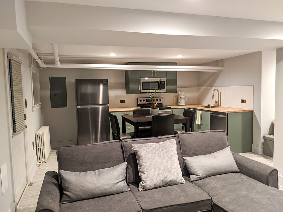 Open-concept living area, with view of full kitchen and dining table.