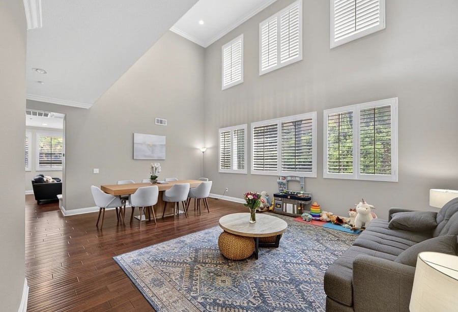 Downstairs features a spacious dining are with large dining table, along with a comfortable sofa for lounging and relaxing in a welcoming, open living space.
