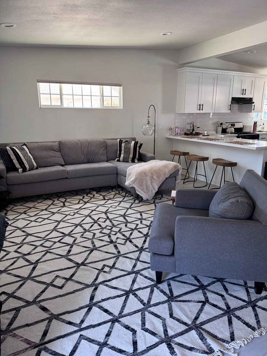 Living room open into the kitchen & dining with a queen size pull out couch. Island peninsula with barstools along with a gas range, beautiful tiled backsplash & brand new fridge make this space bright, functional & perfectly suitable for small gatherings. 
