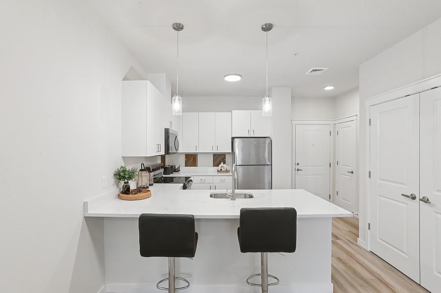 Fully equipped kitchen with stainless steel appliances and quartz countertops.