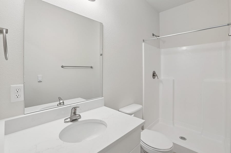 Main bathroom off entry way with vanity, toilet, and shower/tub combo.