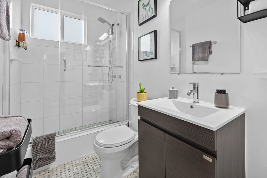 Large vanity and glassed shower with shampoo, conditioner and body wash