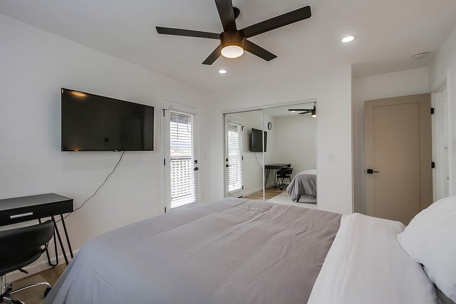 Spacious and peaceful primary suite featuring a comfortable bed, natural light, ample storage, and a relaxing atmosphere designed for extended stays.
