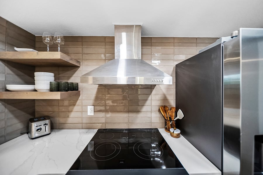 Stocked with dishes, pots and pans, glassware, and utensils.