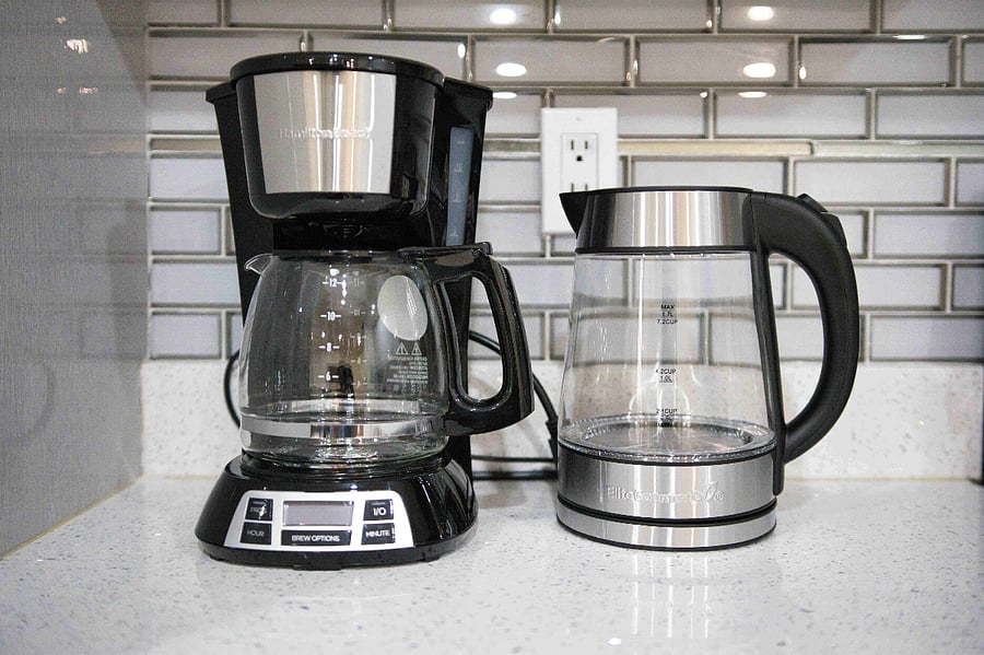 Coffee maker and kettle located in the fully equipped chefs kitchen, perfect for brewing a fresh cup of coffee in the morning or quickly boiling water for a soothing cup of tea anytime during your stay.
