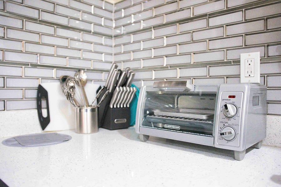 Complimentary toaster, knives, spoons, and cutting board available for guest use within the space.