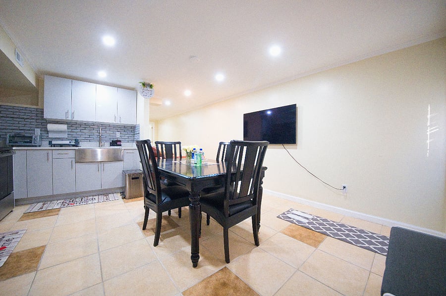 Another wide-angle view of the bright, welcoming kitchen, showcasing its modern appliances and thoughtful amenities, along with a glimpse of the adjoining dining area (perfect for enjoying meals