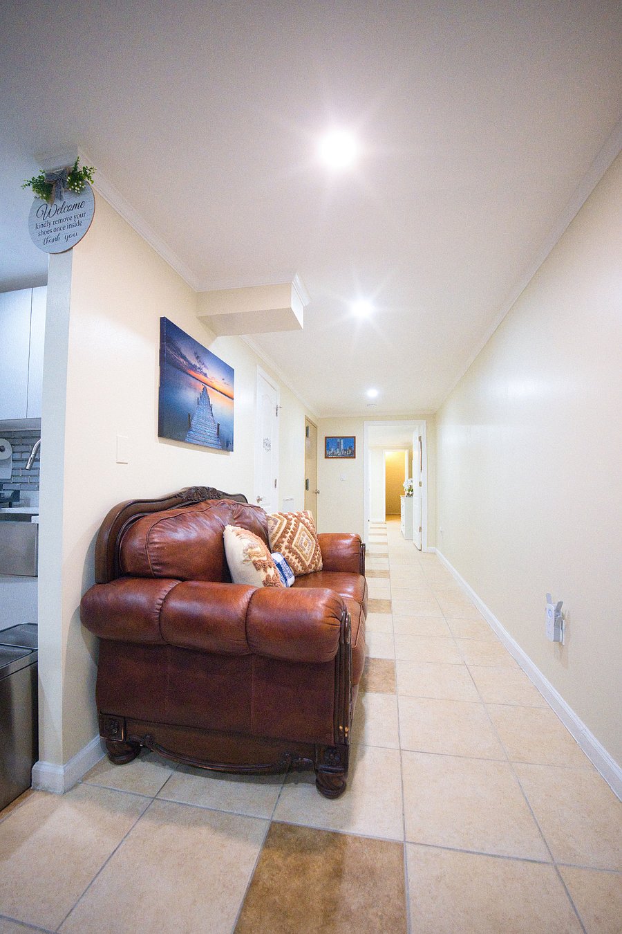 Hallway leading to the full bathroom and main bedroom, featuring a comfortable couch along the way. This is perfect for relaxing and unwinding as you move through the space during your stay.