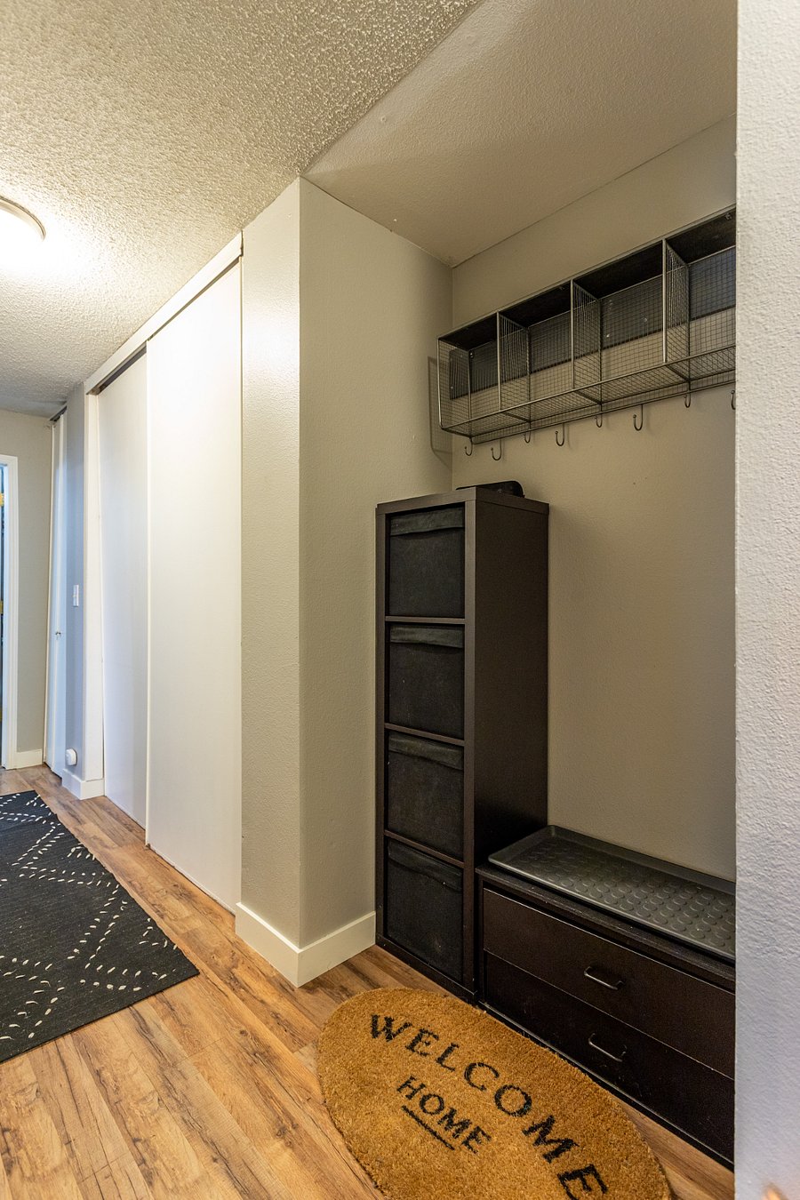Open storage by the entryway for coats, bags, and other outdoor wear. A boot tray is available for winter weather. Lots of additional storage is available in the sliding hallway closets.