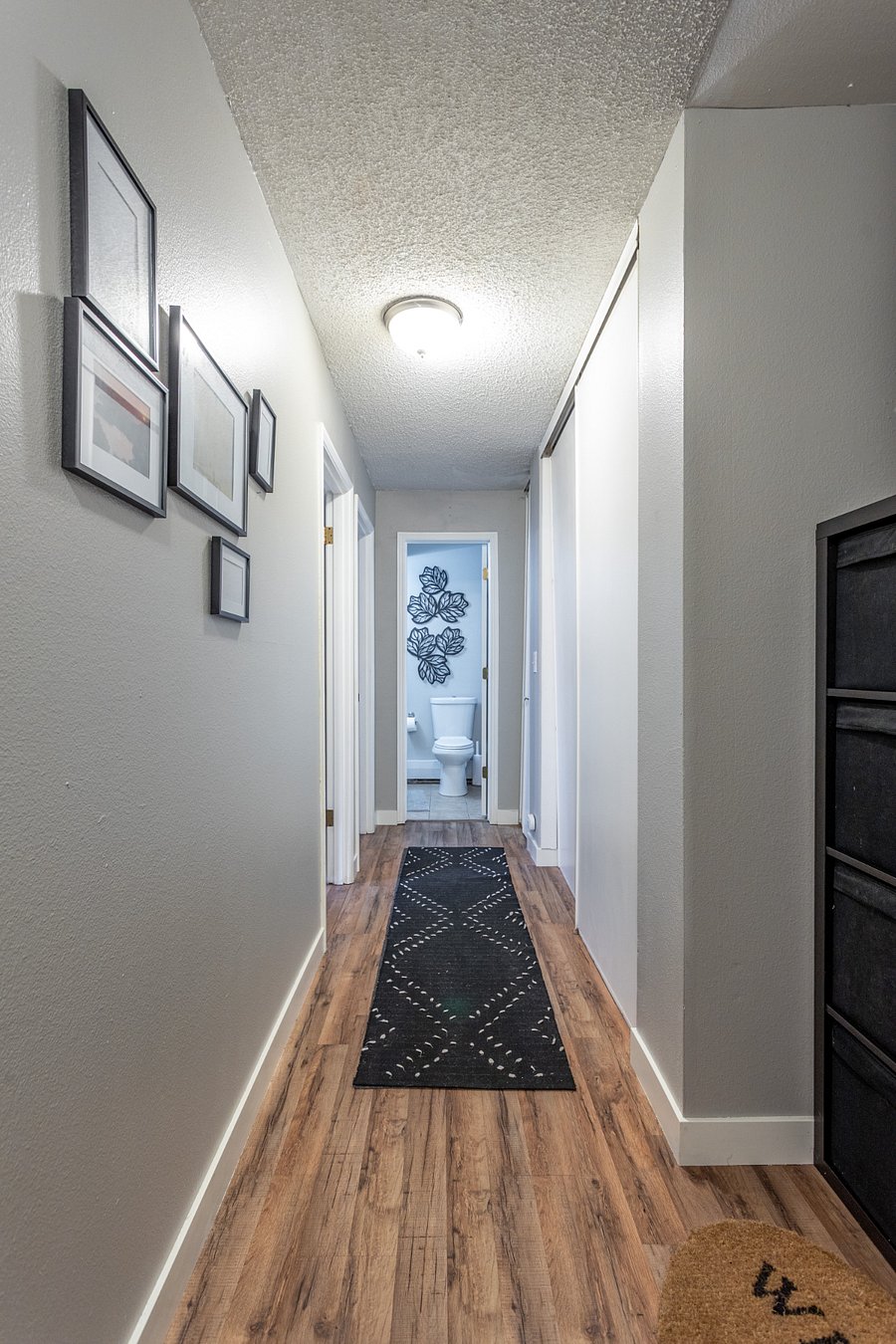 Hallway is lined with closets with both bedrooms to the left.