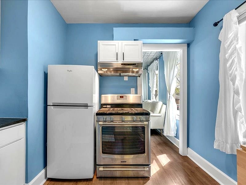 Full size stainless steel gas range and fridge.