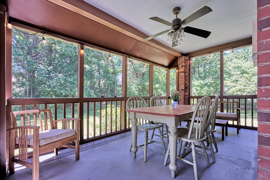 screened porch with dining space and patio furniture