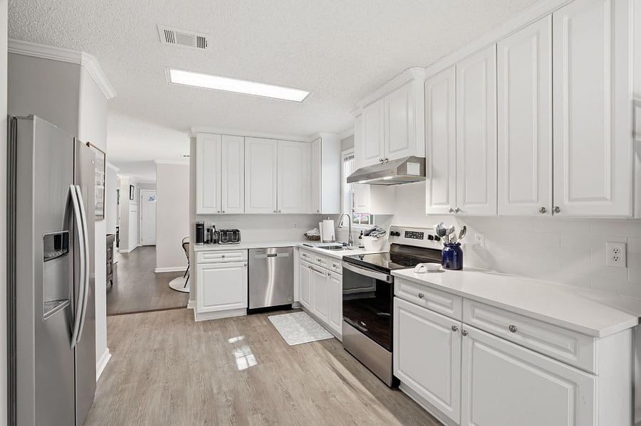 Kitchen with refrigerator/freezer, dishwasher, electric oven and stovetop, microwave and lots of appliances, utensils and cookware for everyday living and meal prep. 