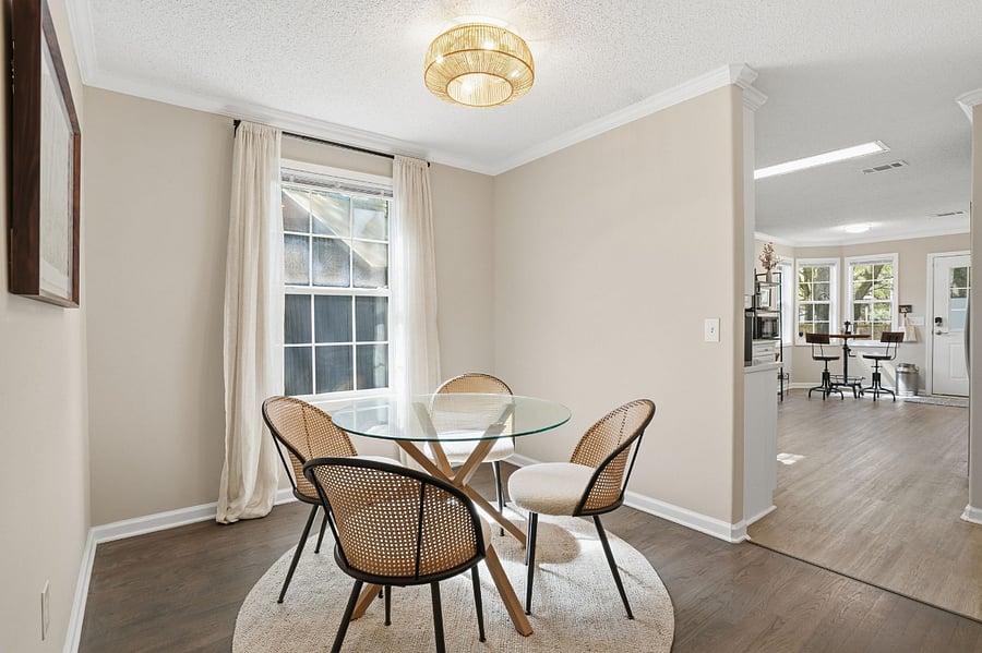 Bright dining room with table for four and ceiling light/fan.