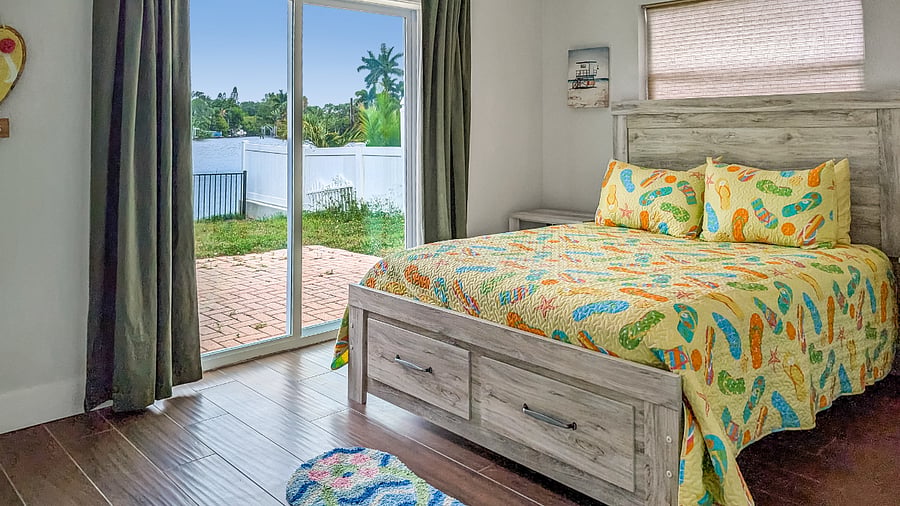 Guest Bedroom 1 features a Queen bed and a beautiful framed view of the water directly from the window.