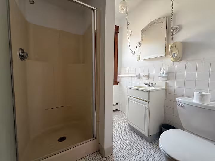 Second floor shared bathroom, shower, toilet, and vanity sink. View from entrance.