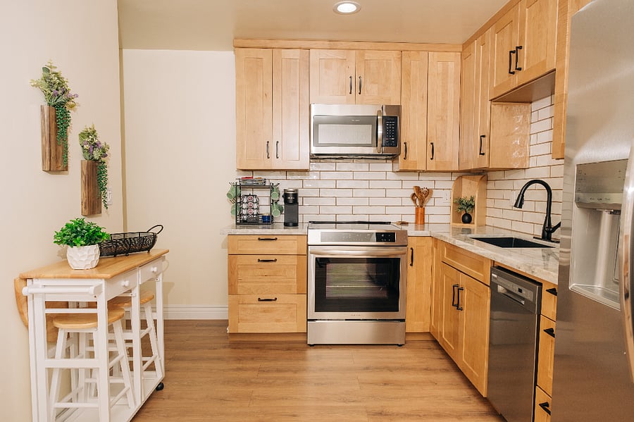 Fully stocked kitchen with side-by-side fridge and freezer including filtered water and ice dispenser, dishwasher, and garbage disposal