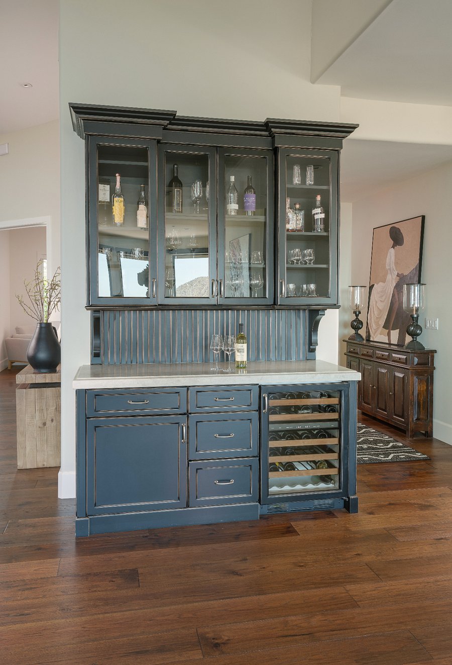 A fully built-out bar just off the kitchen, complete with a wine fridge, glass-front display cabinets, and marble countertop. Whether you're pouring a glass after a long day or hosting friends for the evening, this space makes it effortless.