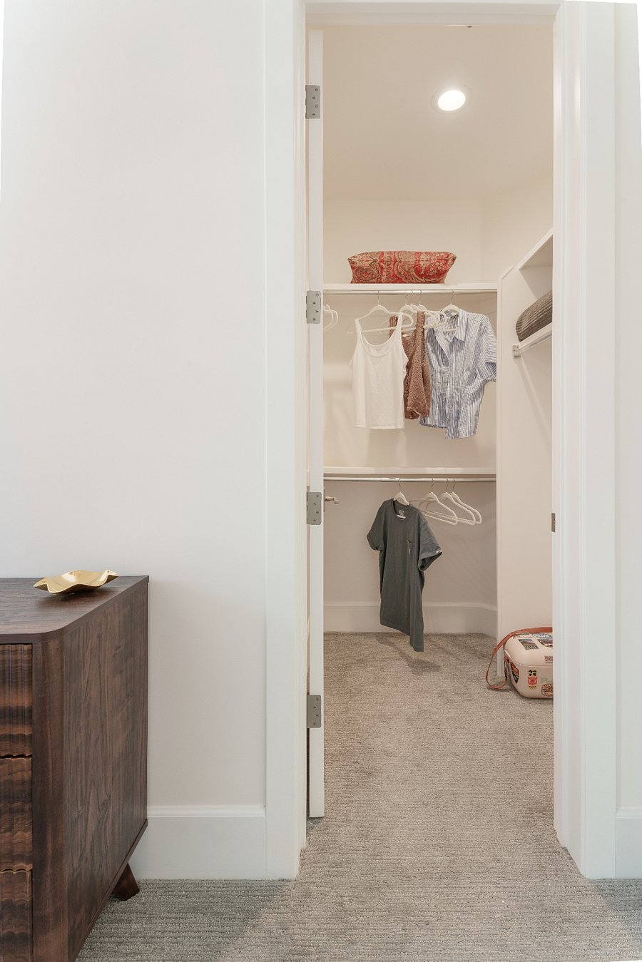 King bedroom with upholstered headboard, nightstands and dresser, plantation shutters, ceiling fan, and a dedicated walk-in closet.