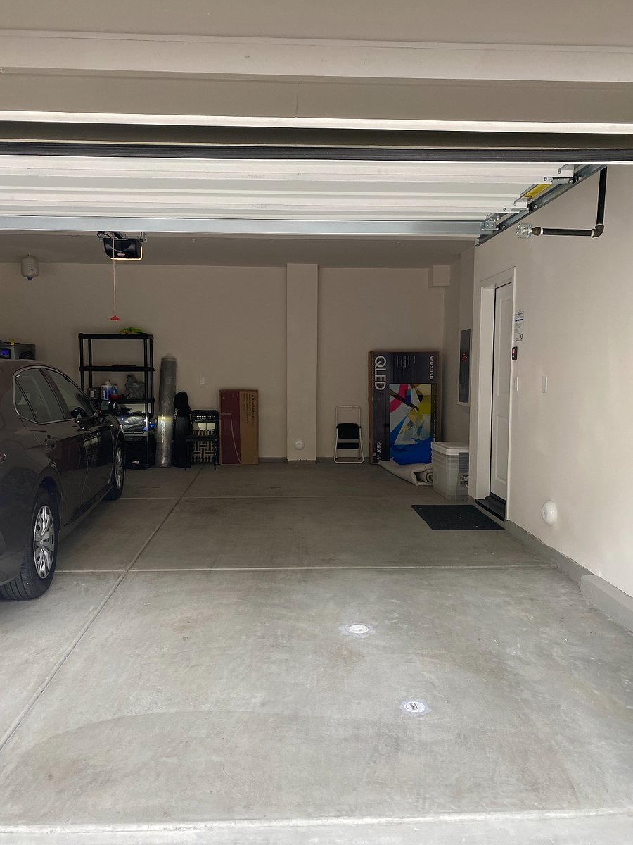 Parking spot in garage. EV charger is on the wall around the corner just past the right door.