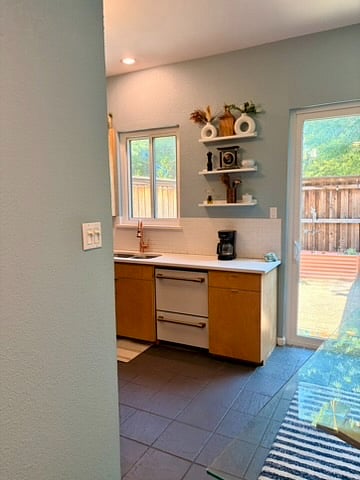 The kitchen has a modern two-drawer dishwasher and a beautiful backyard.