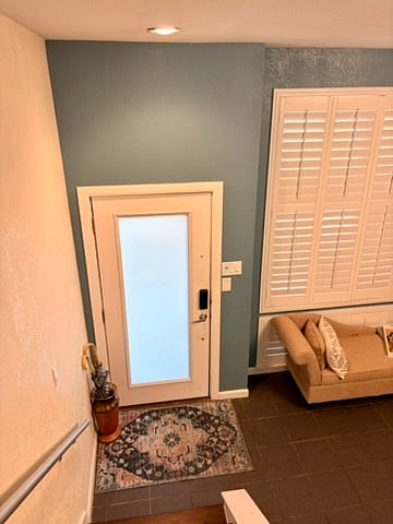 The interior front door featuring a frosted front door and white shutter blinds.