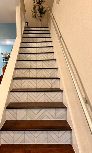The stairs leading upstairs with dolomite chevron marble honed mosaic tile.