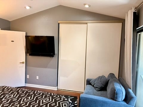 The primary bedroom has a 46 inch television conveniently mounted to the wall and a large closet next to it.