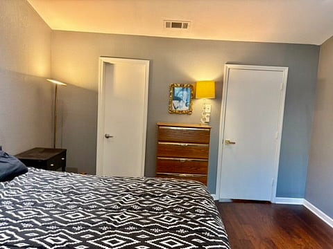 The primary bedroom view toward the interior of the home, with the door on the left entering the pass through bathroom.