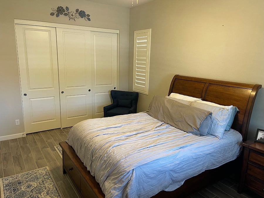 Bedroom #1 w/ Queen Bed, Dresser, Nightstand, Closets, and Two Chairs.