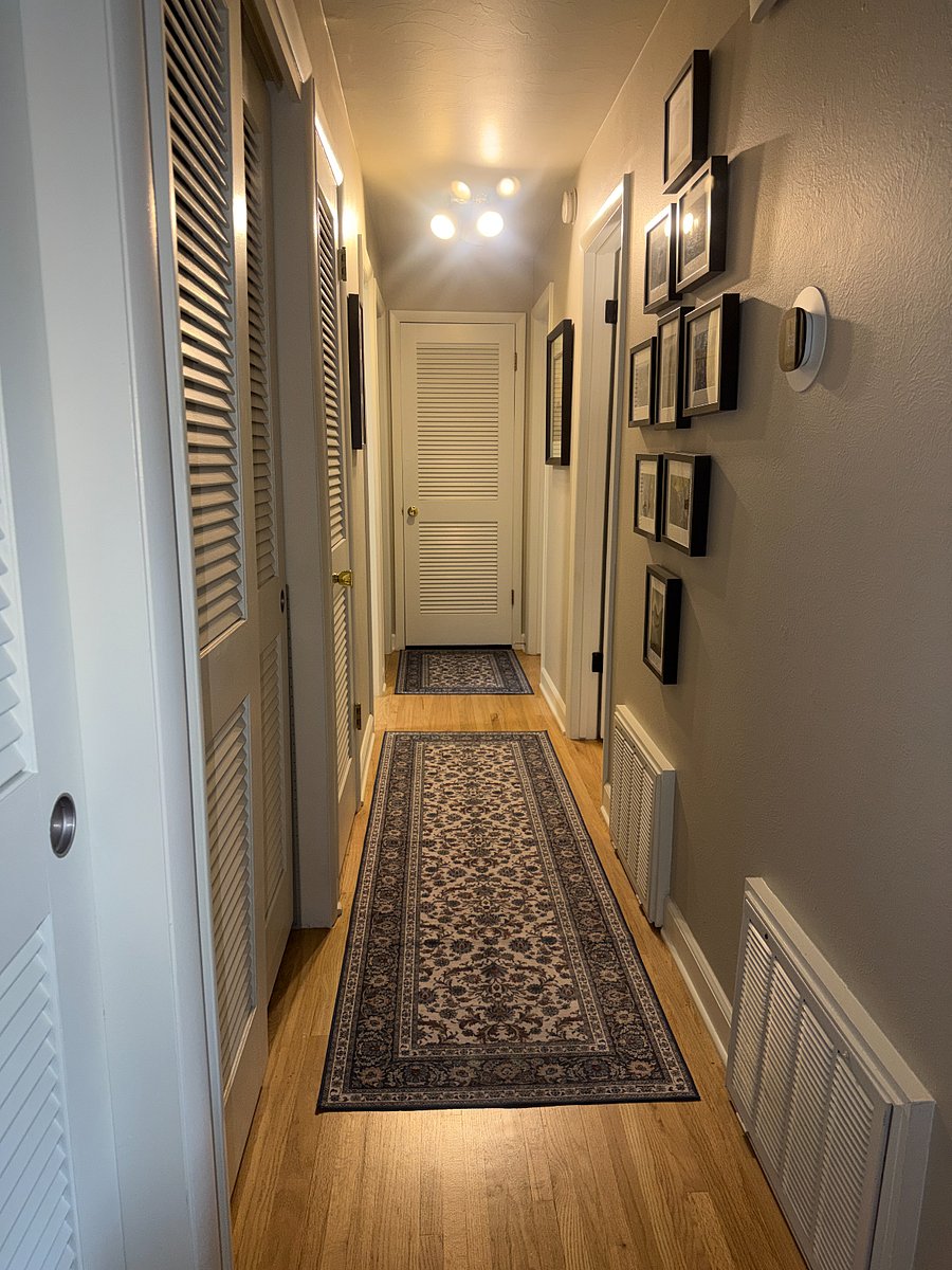 Gallery wall hallway with closets leading to bedrooms/office and bathrooms