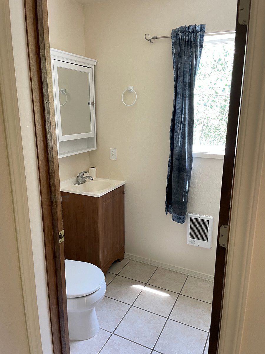 Bathroom with vanity, medicine cabinet, heater and window
