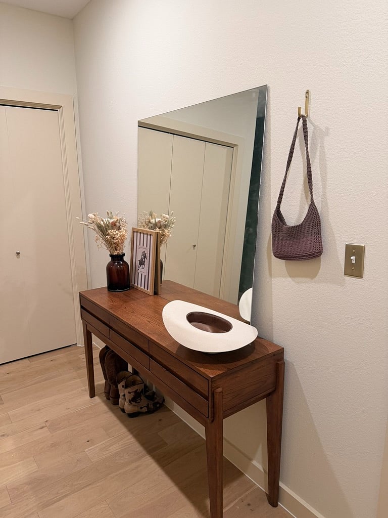 Entryway storage and large mirror leading to laundry closet with full size in-unit washer and dryer.