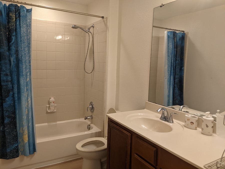 Spacious bathroom is fully supplied with towels and toilet essentials. 