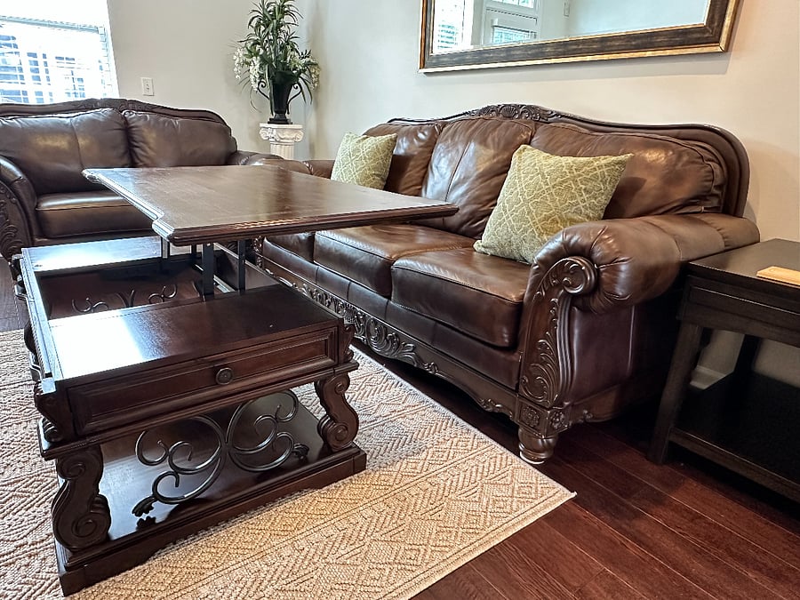 Coffee table goes up to accommodate the people sitting on the main leather couch (fits 3 people)