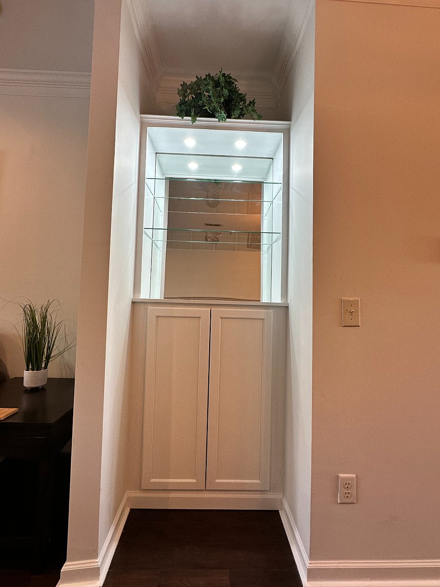 Beautiful built-in glass display in the living room with additional storage underneath.